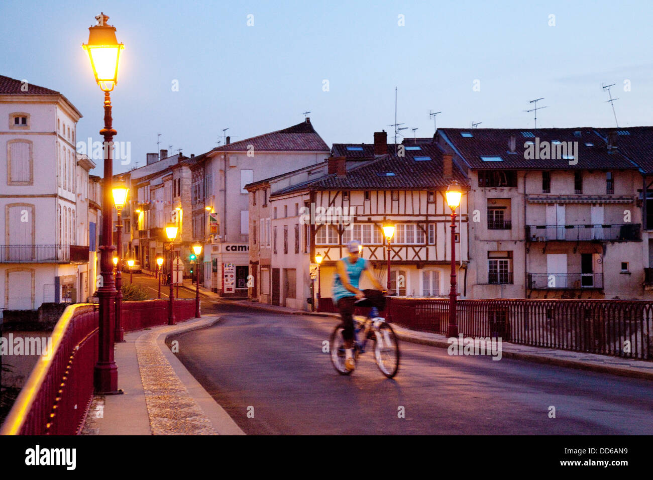 Ein Mann Radfahren in der Nacht in der französischen Stadt Villeneuve sur Lot, Lot-et-Garonne, Frankreich Europa Stockfoto