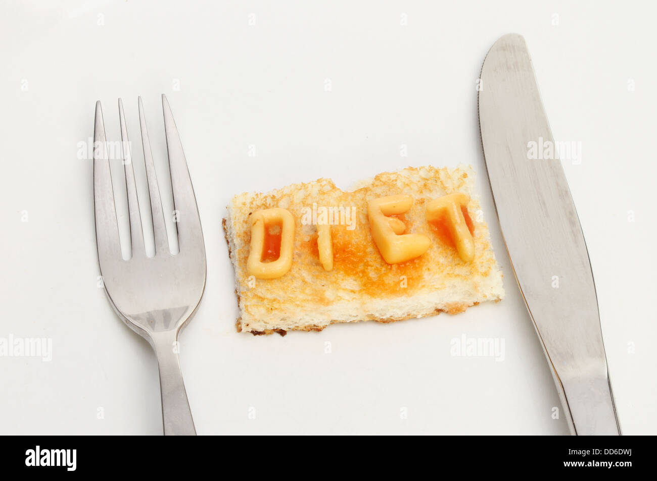 Diät-Konzept, Toast mit das Wort Diät geschrieben mit Alphabet Nudeln auf einem Teller mit Messer und Gabel Stockfoto