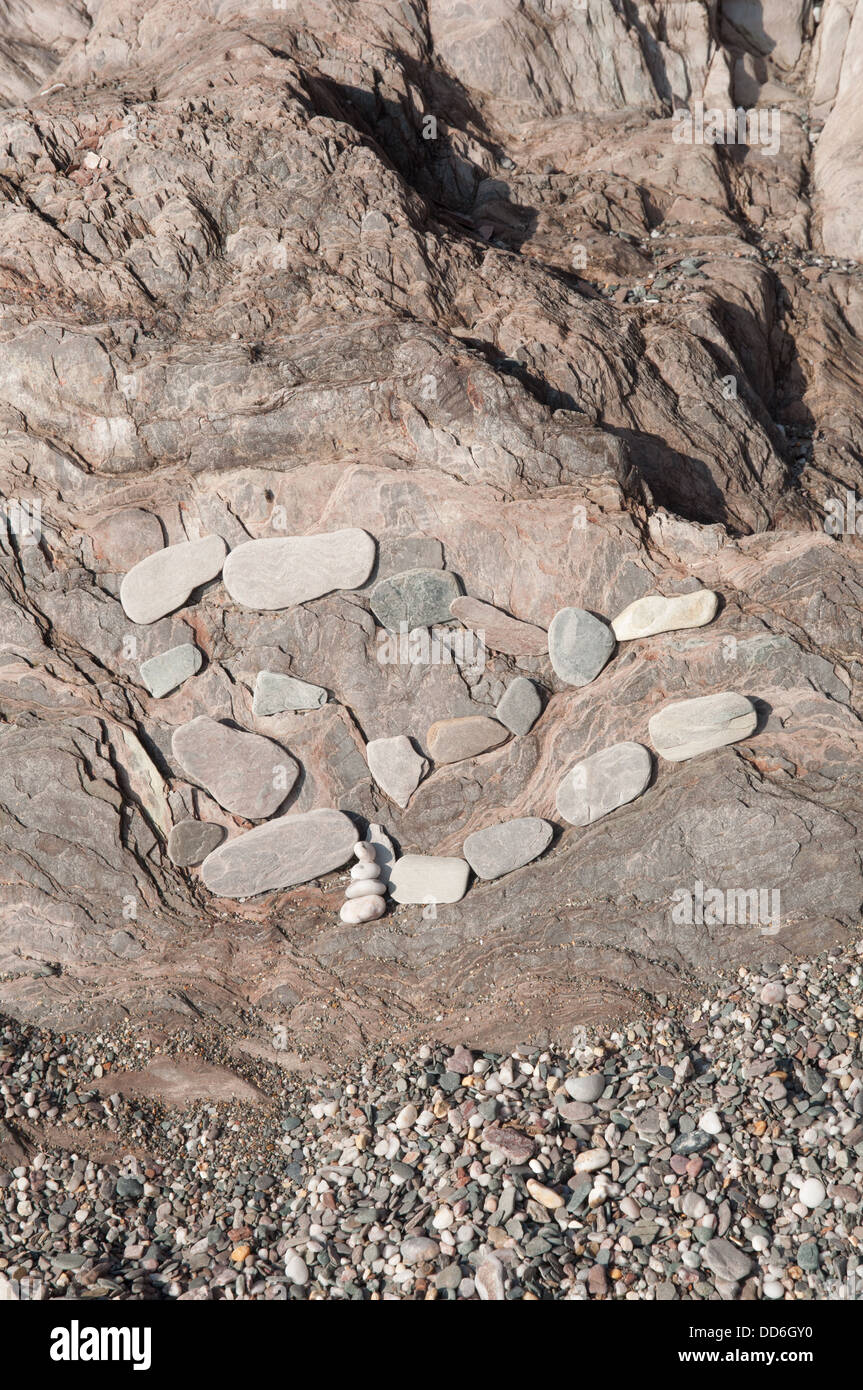 Gruppe von flachen Steinen angeordnet auf Felsen am Ufer Stockfoto