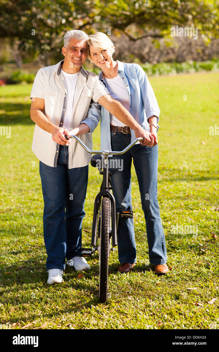 fröhliche mittleren gealterten paar zu Fuß ein Fahrrad in der Natur Stockfoto