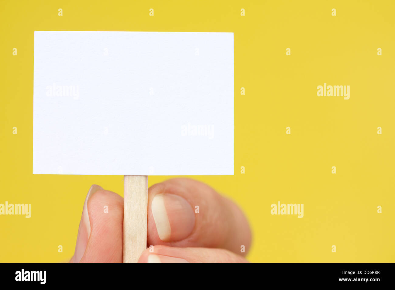 Hand mit winzigen Schild Gelb mit Textfreiraum Stockfoto