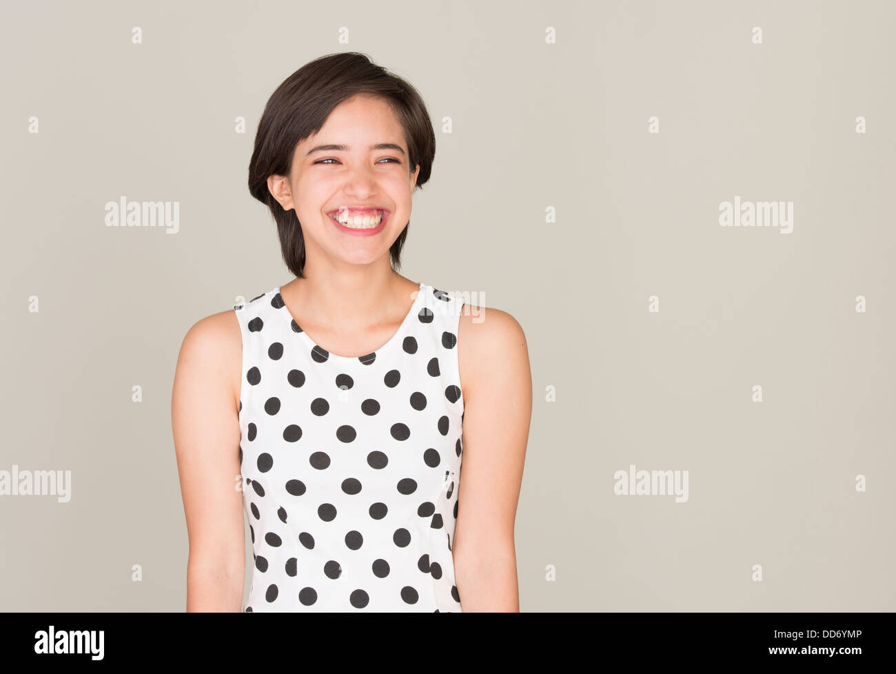Glückliche junge Frau mit gepunkteten Kleid lachen Stockfoto