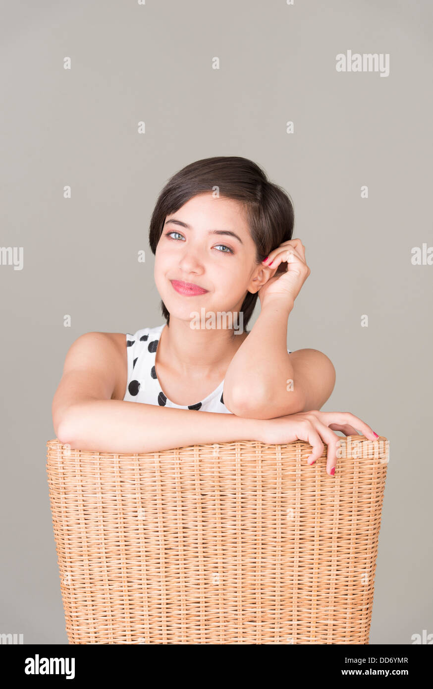 Junge, selbstbewusste Frau sitzen im Sessel Blick in die Kamera und lächelnd Stockfoto