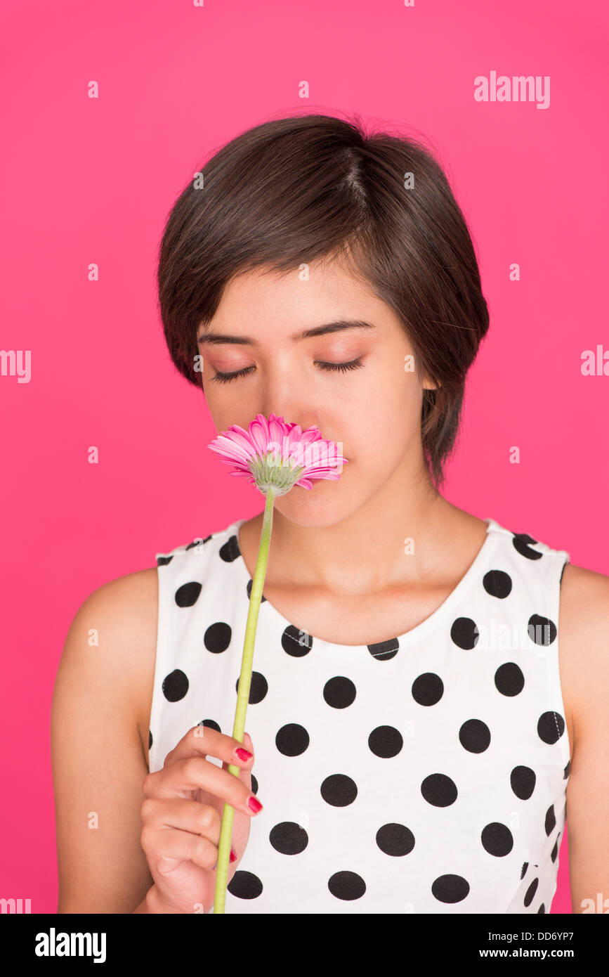 Romantische Porträt jungen multirassische Frau riechen eine Gerbera Daisy mit geschlossenen Augen Stockfoto