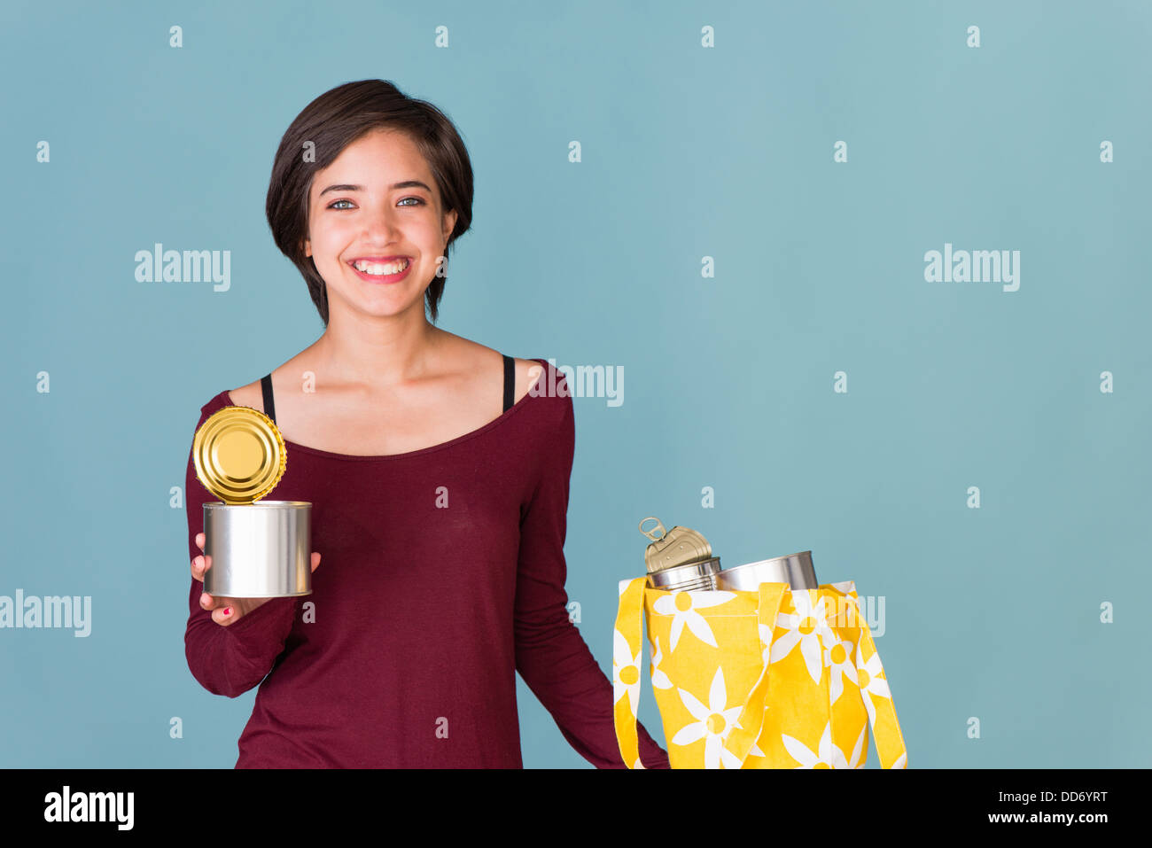 Porträt von lächelnden jungen multirassische Frau recycling Metall Dosen Stockfoto