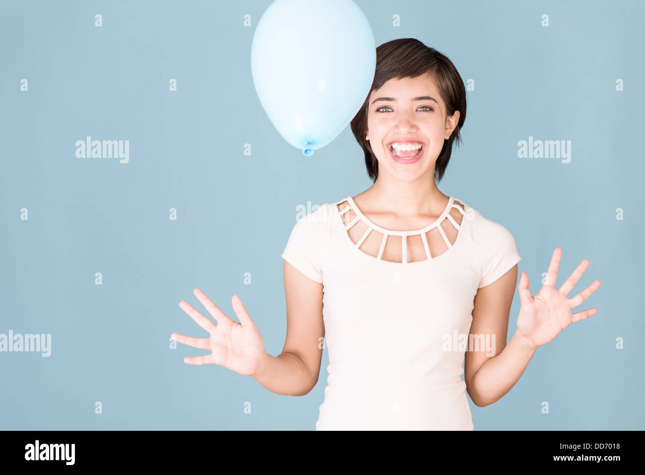 Schöne junge Frau multirassische feiern und spielen mit blauen Ballon Stockfoto