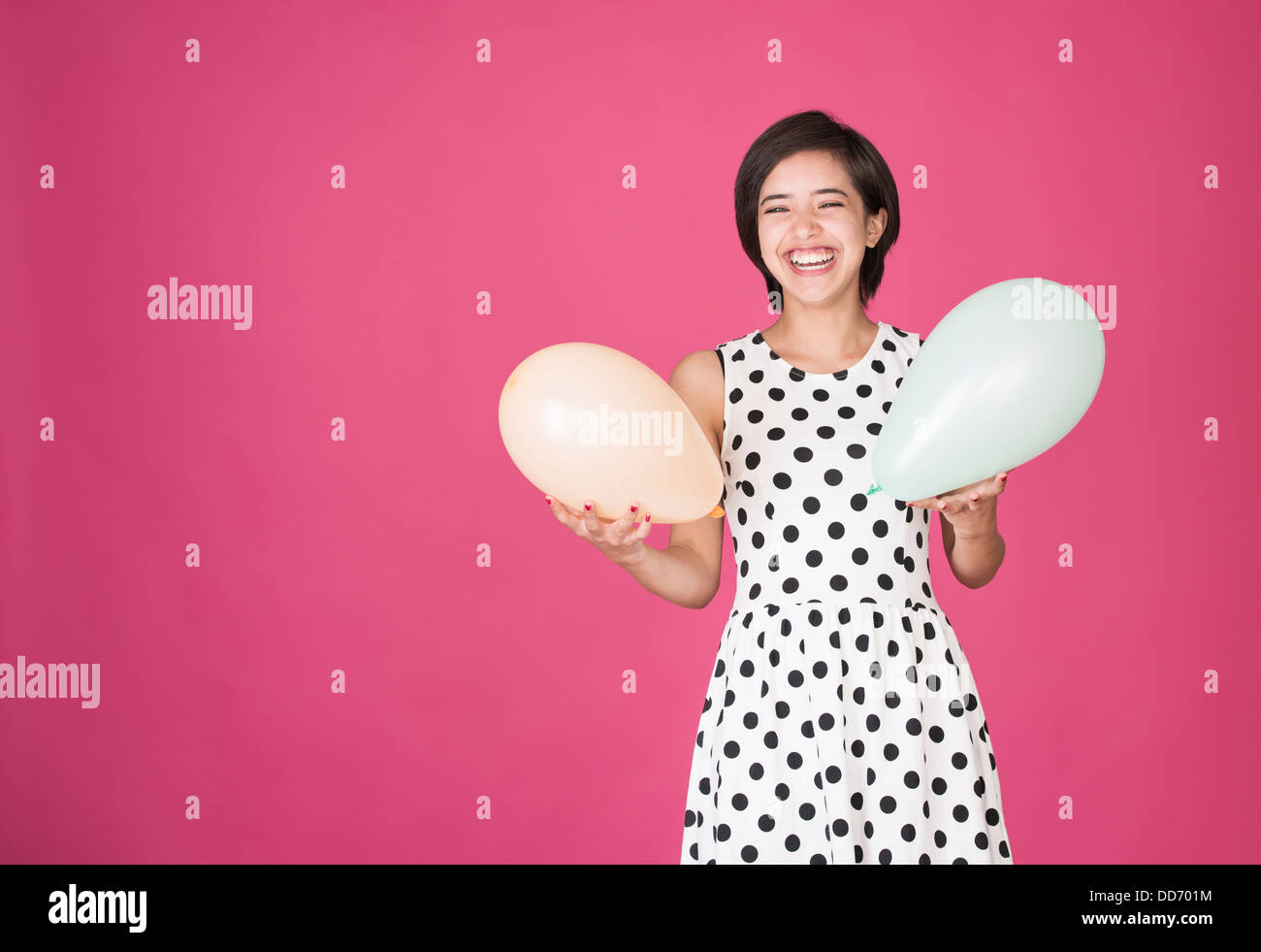Schöne junge multirassische Frau Spaß mit zwei Ballons an der Feier Stockfoto
