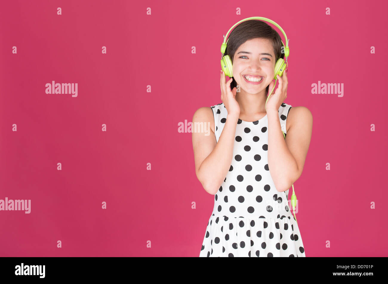 Schöne junge Frau multirassische Lachen und Musikhören mit grüne Kopfhörer Stockfoto