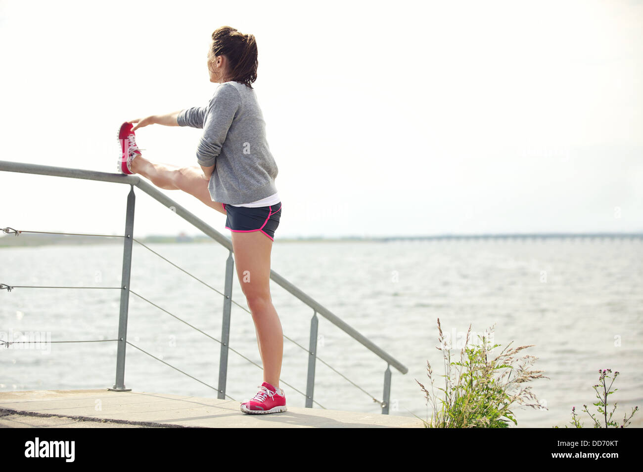 Aktive junge weibliche Läufer ihre Beine im Freien vor dem Training ausführen. Aktiven Lebensstil. Stockfoto