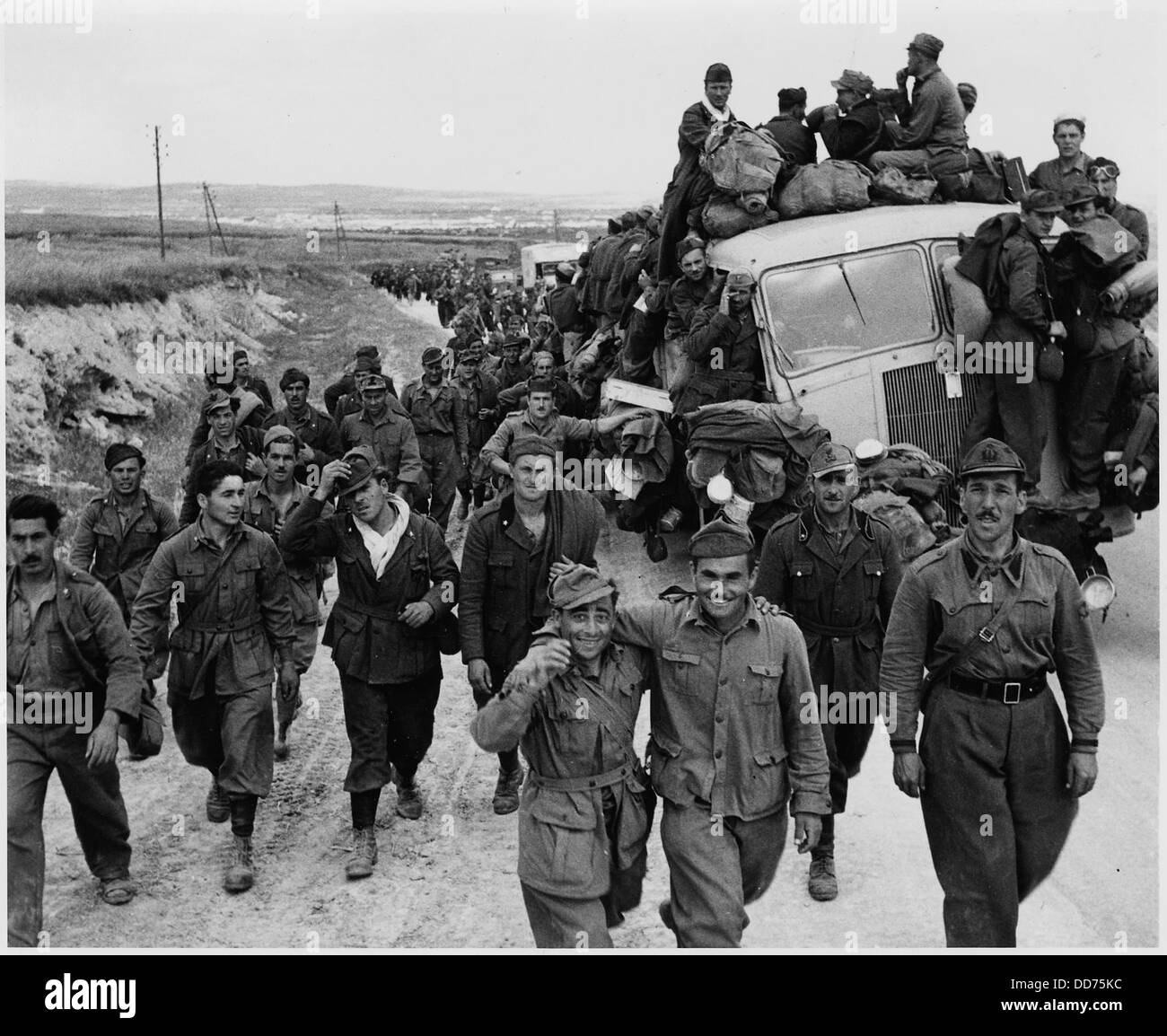 Axis Kriegsgefangene werden von alliierten Streitkräften aus Tunis begleitet, während sie in die Stadt vorrücken, was einen wichtigen Moment in der nordafrikanischen Kampagne des Zweiten Weltkriegs darstellt. Stockfoto