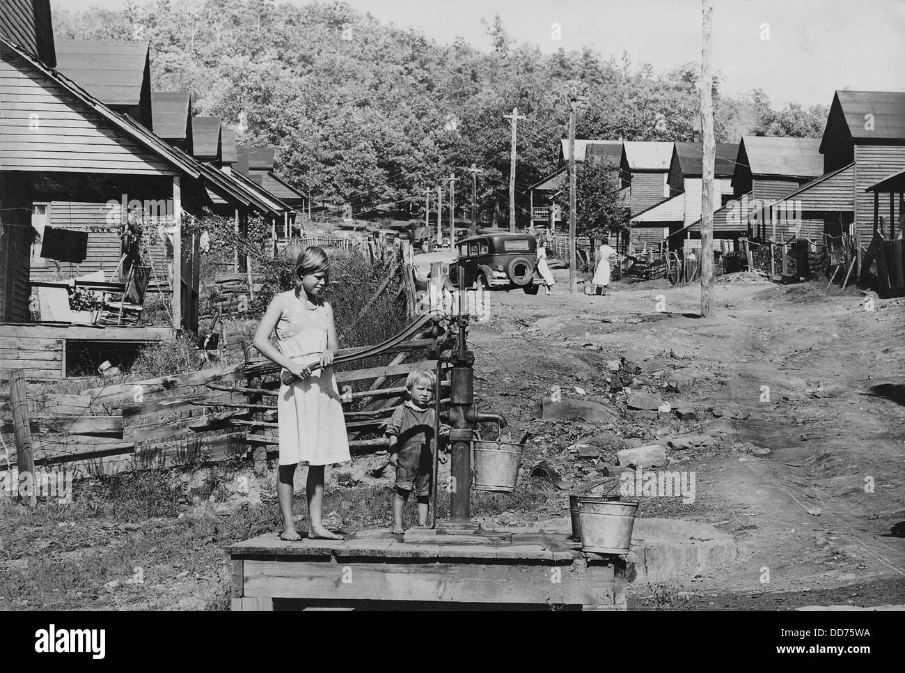Barfuß Kinder Pumpwasser in Wilder, Tennessee, ca. 1935. Die Pumpe ist die einzige Wasserversorgung in diesem Teil der Stadt. Stockfoto