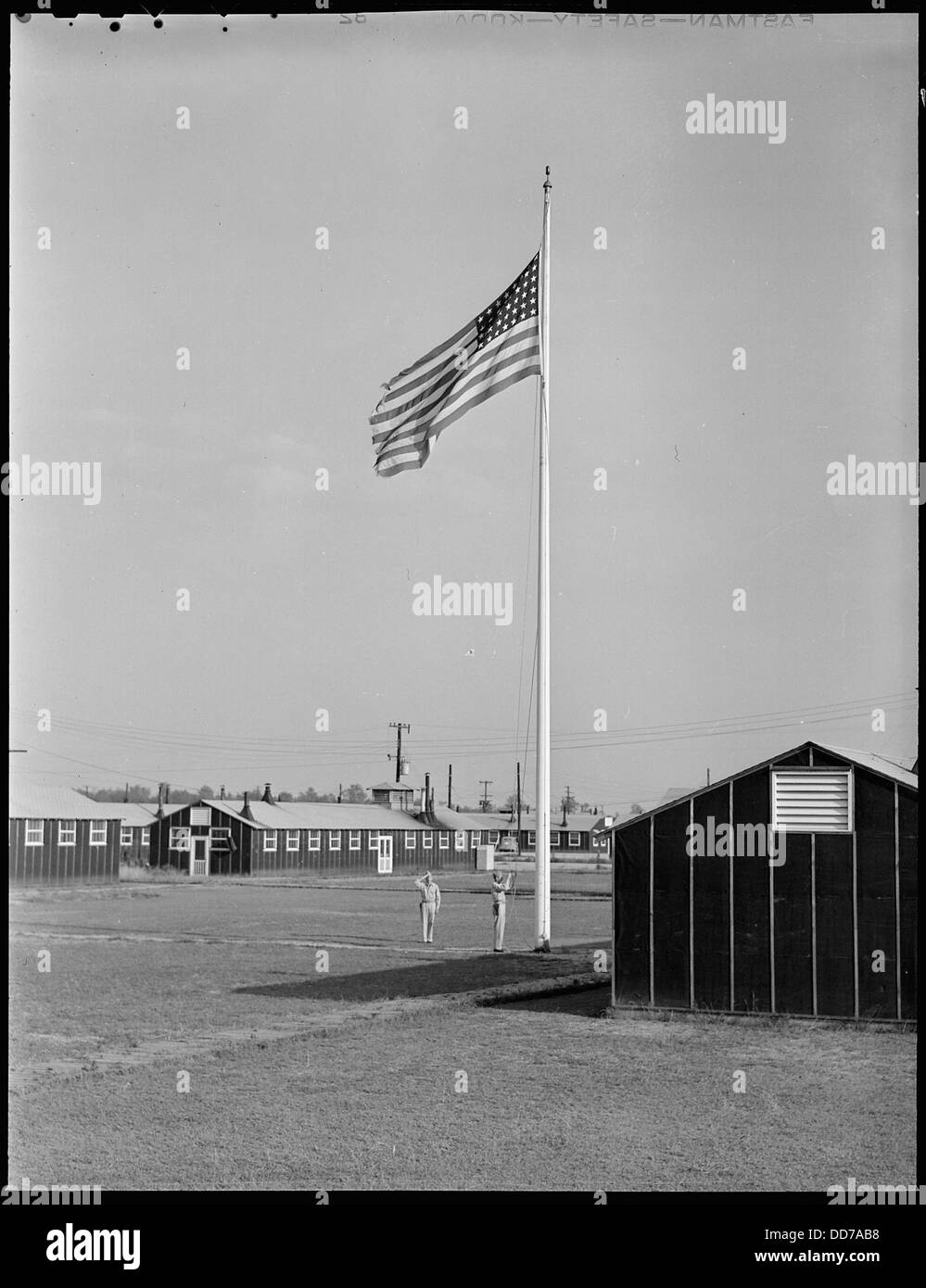 Dieses Bild zeigt den Moment, in dem Old Glory zum letzten Mal im Jerome Relocation Center in Denson, Arkansas, gesenkt wird, was das Ende des Internierungslagers markiert. Stockfoto