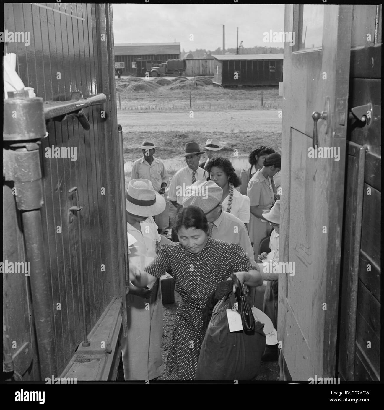 Eine Issei-Frau trägt ihre Sachen, als das Jerome Relocation Center in Arkansas während des Zweiten Weltkriegs geschlossen wurde, was das Ende der Internierung durch die Japaner markiert. Stockfoto