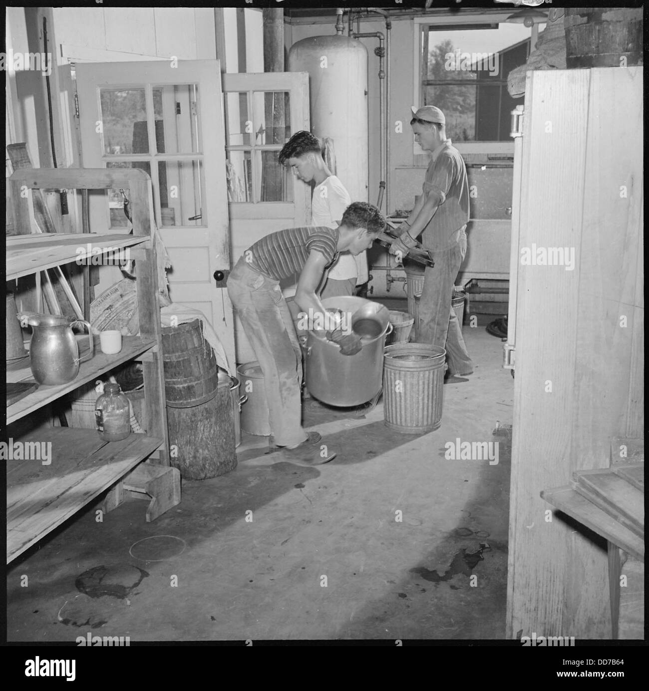 Dieses Foto zeigt die Schließung des Jerome Relocation Center in Denson, Arkansas. Das Bild zeigt Einzelpersonen, die während des Umzugs Geräte im Rahmen des Demontageprozesses bewegen. Stockfoto