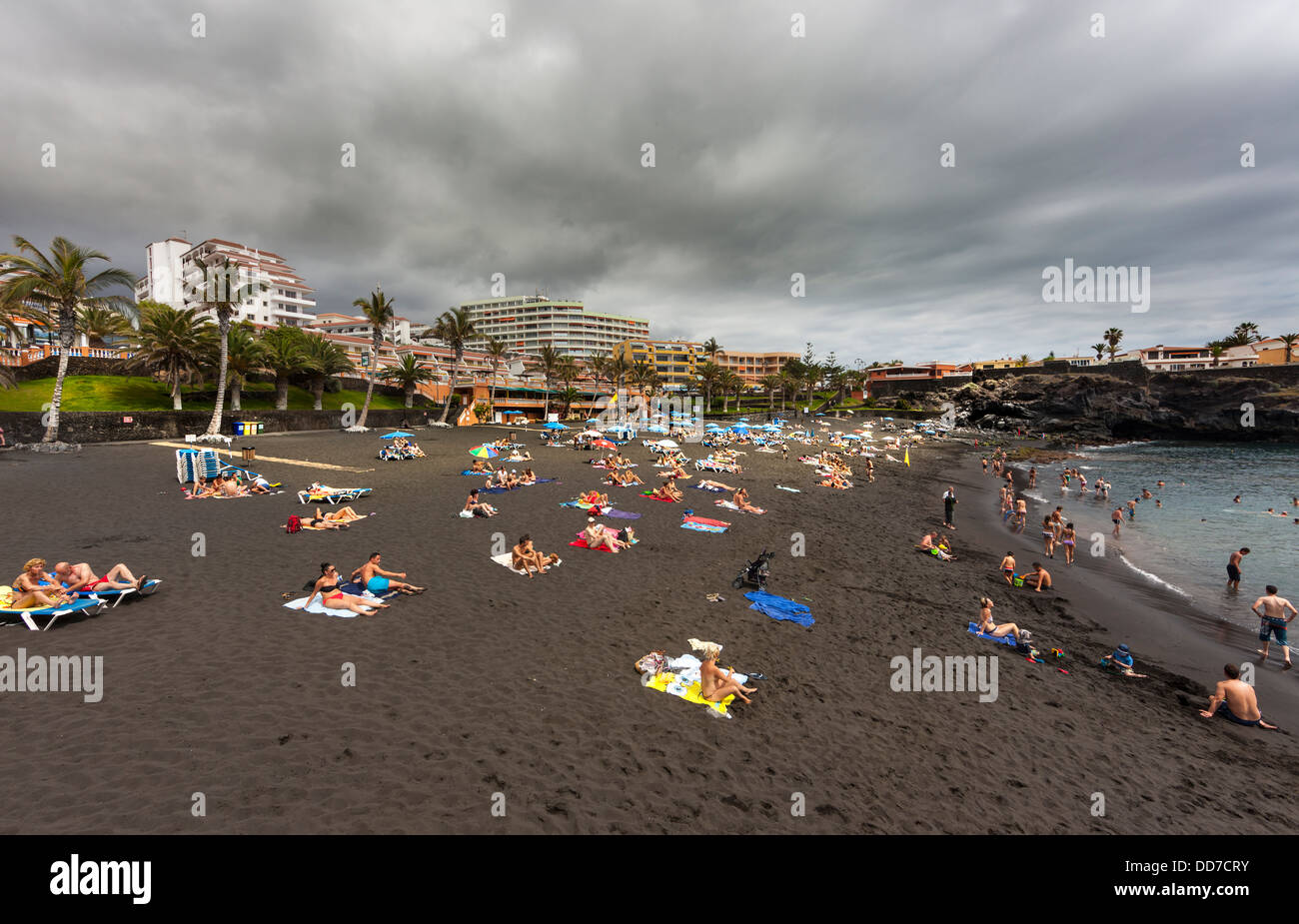 Spanien, Menschen, die am schwarzen Sandstrand entspannen Stockfoto