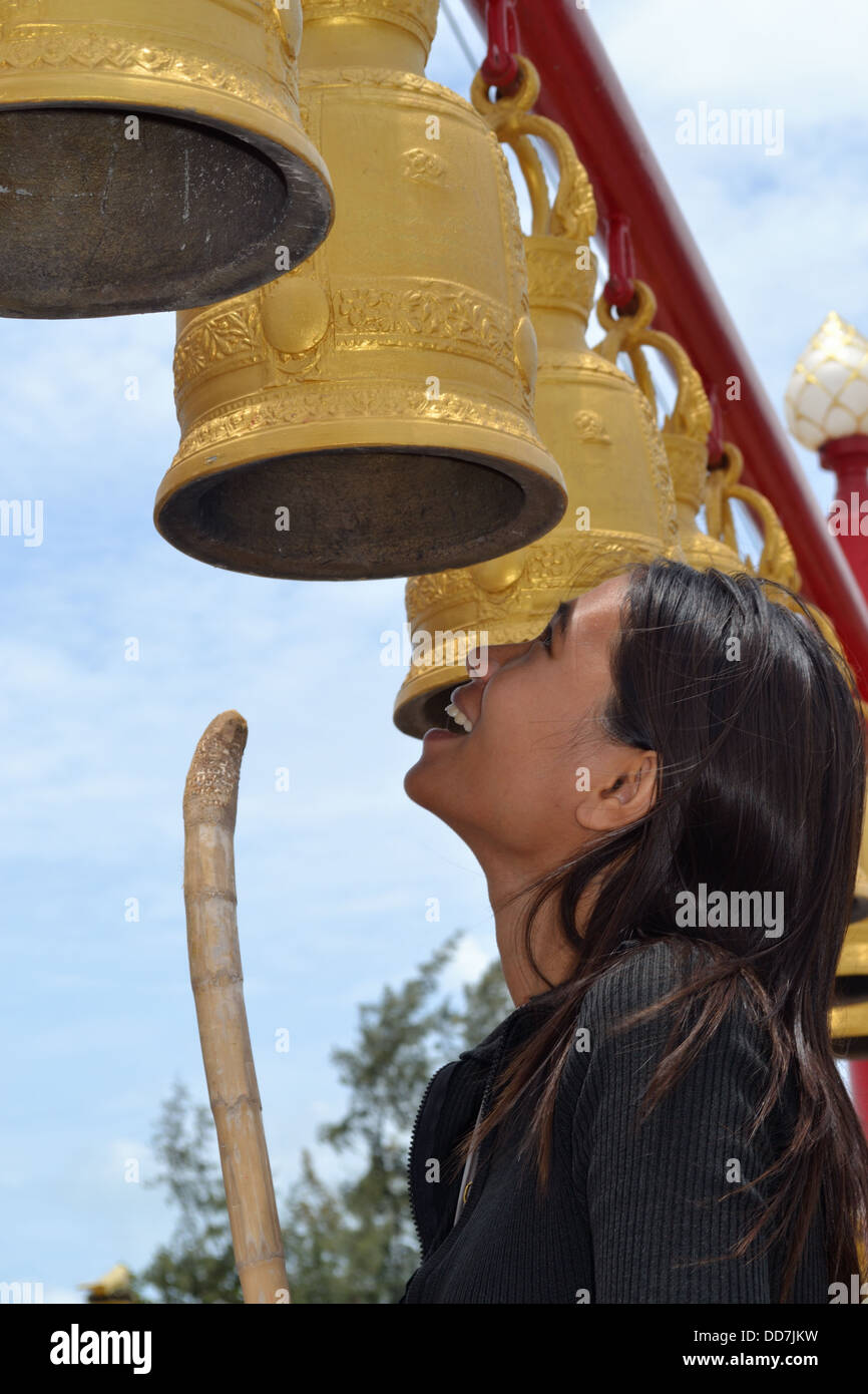 Thai Dame schlagen die Wat-Glocken im chinesischen Tempel - Ban Chang Rayong Stockfoto