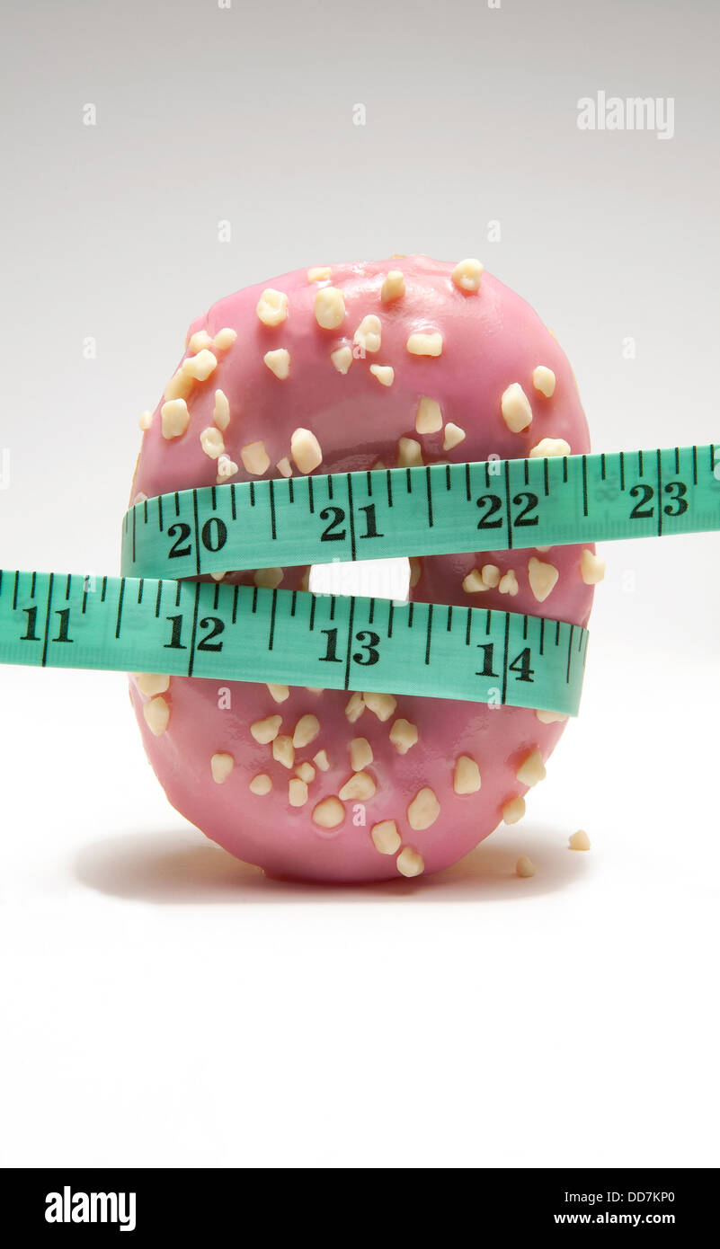 Maßband um Rosa iced Donut gewickelt Stockfoto