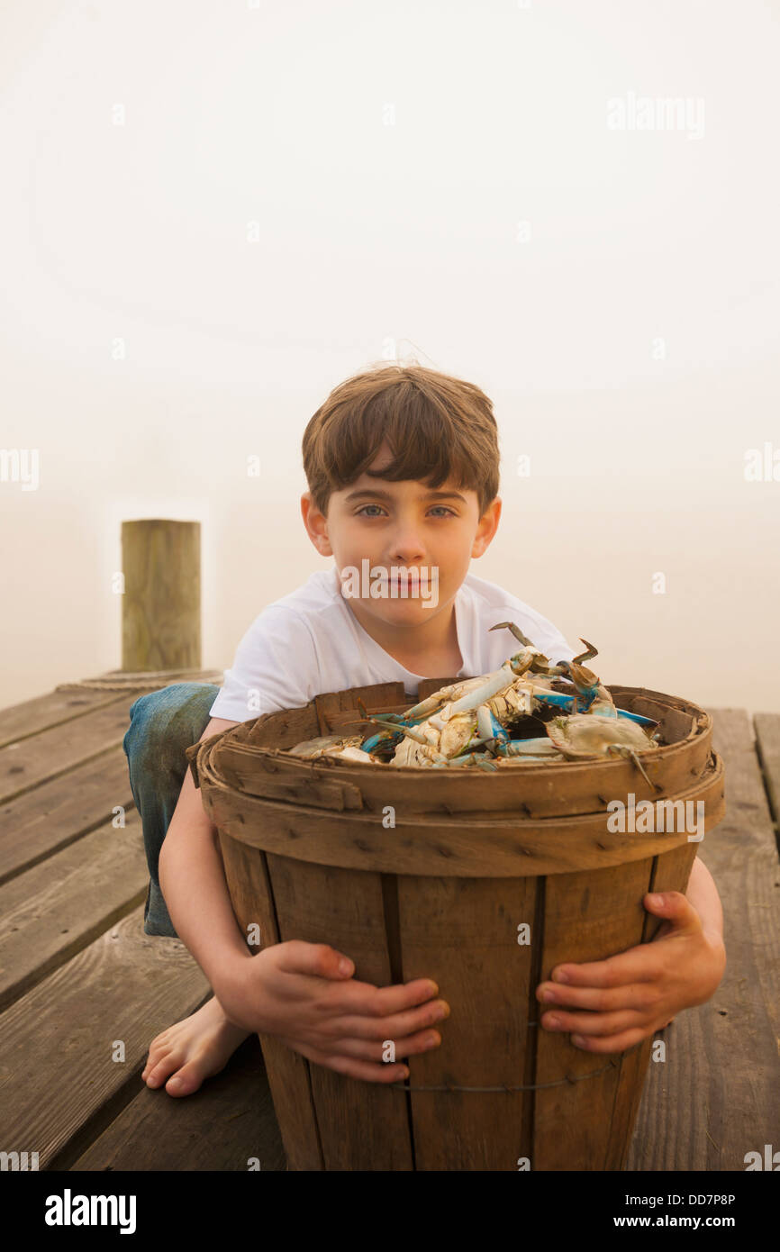 Kaukasische junge Korb voller Krebse halten Stockfoto