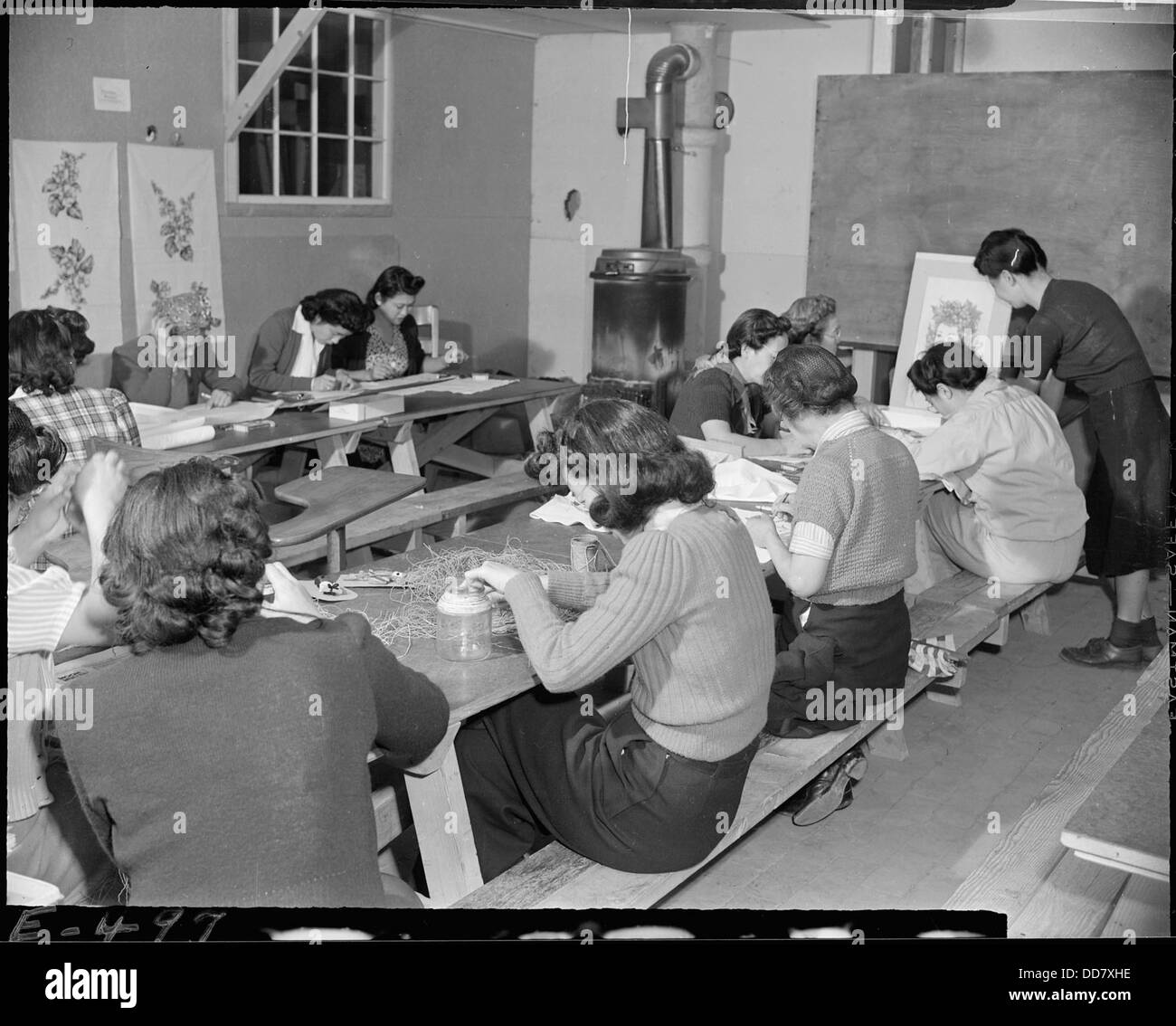 Frauen im Granada Relocation Center in Amache, Colorado, nehmen an einem Handwerkskurs für Erwachsene Teil und lernen während ihrer Zeit im Zentrum Kunst und Handwerk. Stockfoto
