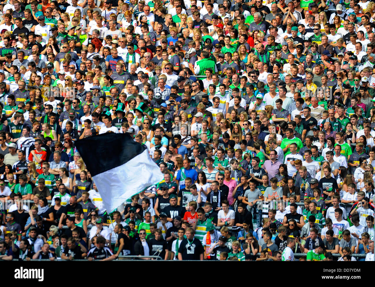 schwarze und weiße Flagge wird vor einer großen Menschenmenge im Fussballstadion winkte Stockfoto