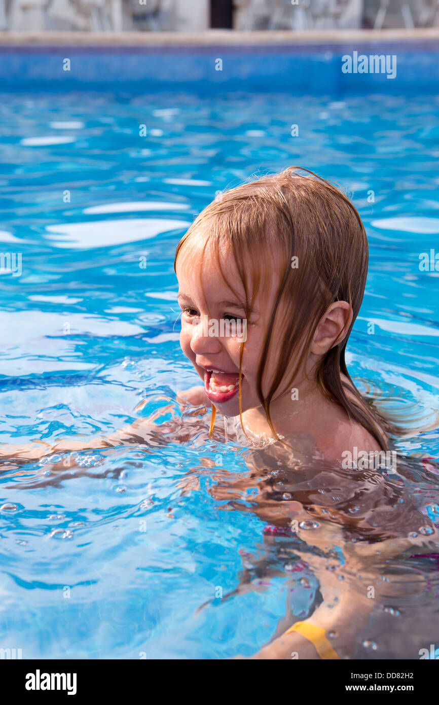 Niedlichen Kleinkind lernen und dabei Spaß im Schwimmbad schwimmen Stockfoto