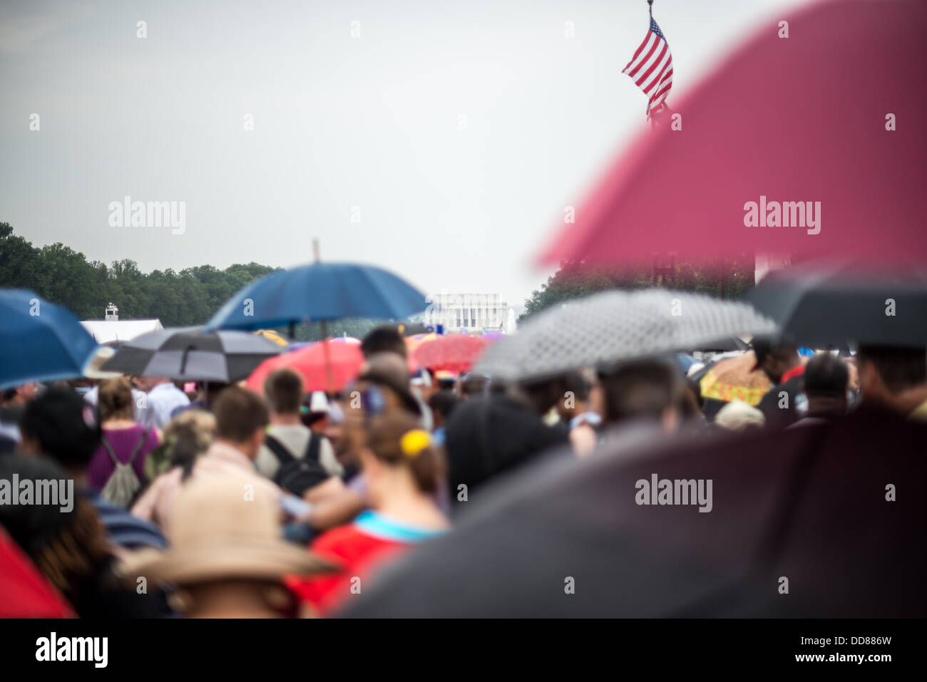 WASHINGTON DC, USA - Menschen schirmt sich von der leichten Regen mit Sonnenschirmen auf der National Mall in Washington DC am Gedenken an den 50. Jahrestag der 1963 Marsch auf Washington berühmt für zivile Rechte Führer Martin Luther King Jr.'s erinnert "Ich habe einen Traum' Rede haben. Stockfoto