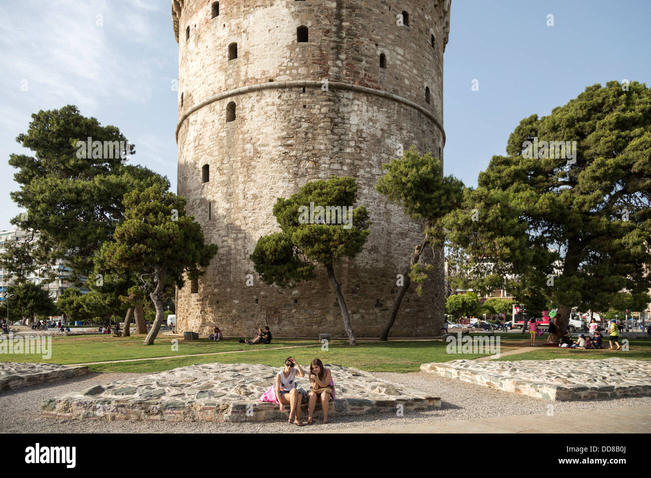 Zwei Mädchen entspannen unter den weißen Turm (Lefkos Pyrgos) in Thessaloniki, Griechenland. Stockfoto