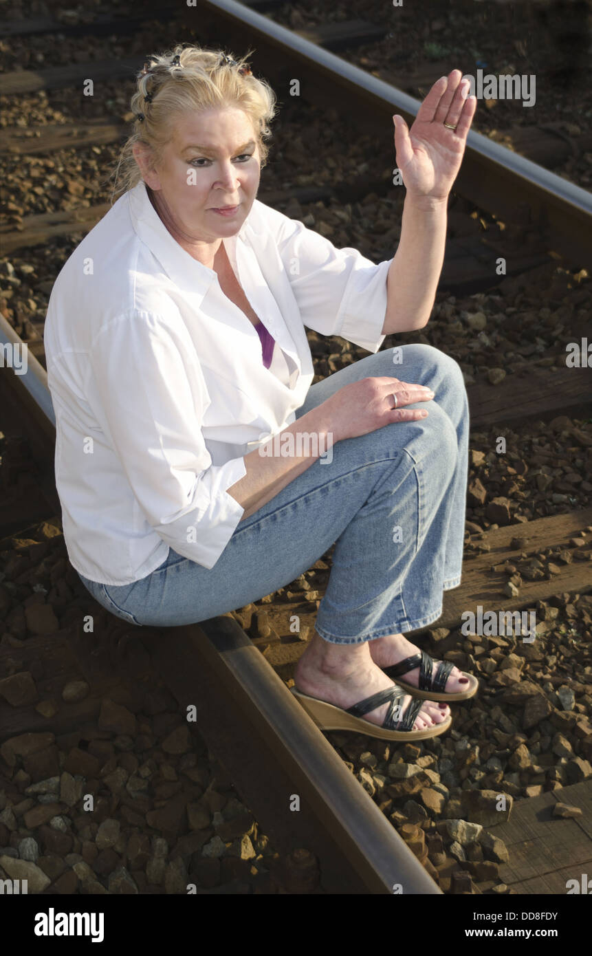 Frau in ihren 50ern weht auf einem Gleis Stockfoto
