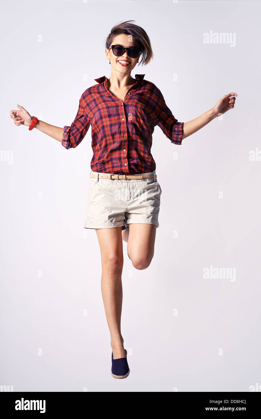 Vertikale Porträt eine energische junge Frau macht eine perfekte Pose beim Springen Stockfoto