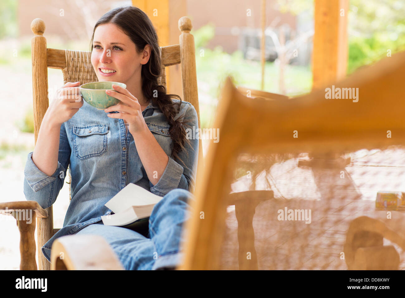 Kaukasische Frau Tasse Kaffee im Schaukelstuhl Stockfoto