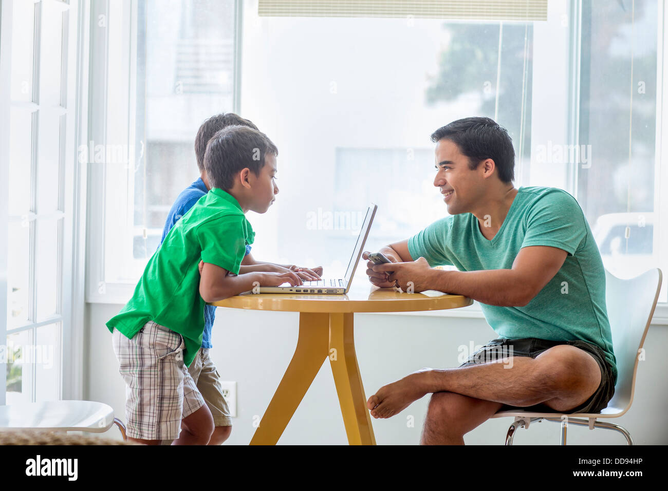 Vater und Söhne am Tisch reden Stockfoto