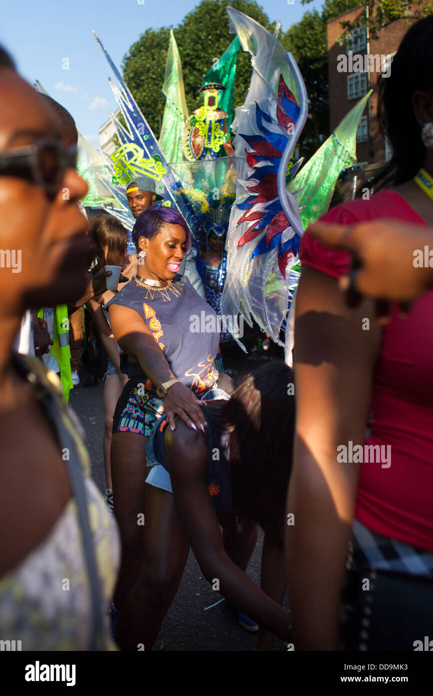 Schwarze Mädchen jammern und freakigen Tanz in der Mitte den Karnevalsumzug und geschäftigen Menge zu tun. Stockfoto