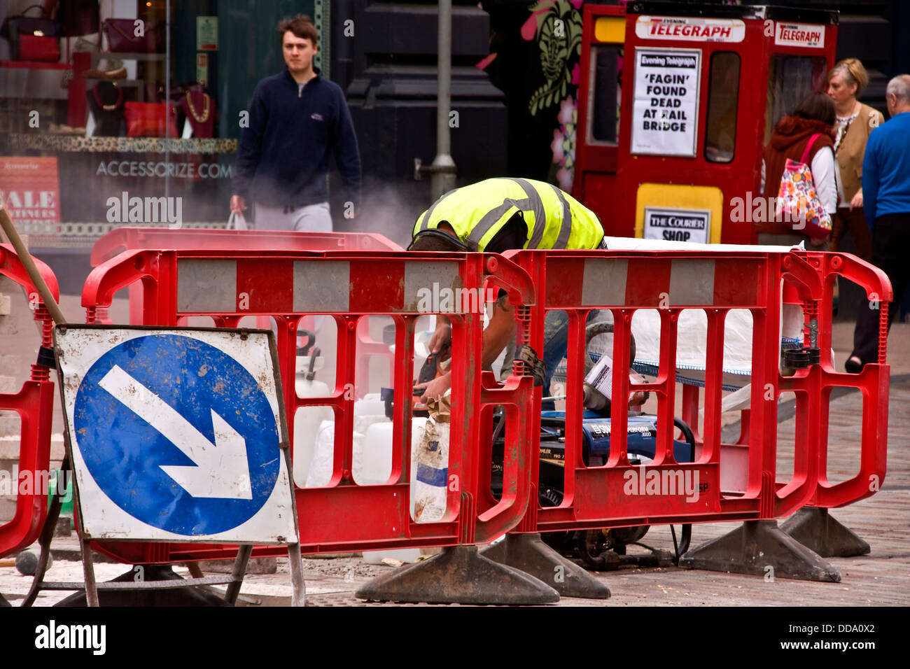 Ein Arbeiter beschäftigt, Schneiden von Betonplatten und die Wiederherstellung der Stadt Bürgersteige in Dundee, Großbritannien Stockfoto