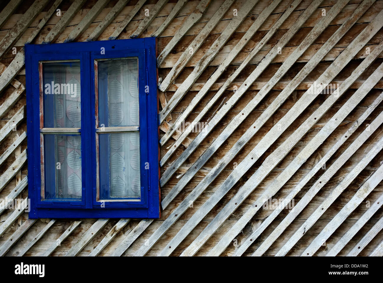 Blauen Fensterrahmen auf die alte Holzhütte. Stockfoto