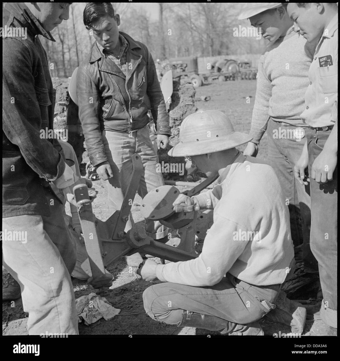 Im Rohwer Relocation Center in McGehee, Arkansas, werden Landarbeiter während des Zweiten Weltkriegs beim Zusammenbauen von Maschinen beobachtet. Dieses Bild gibt einen Einblick in das tägliche Leben im Lager während der 1940er Jahre Stockfoto