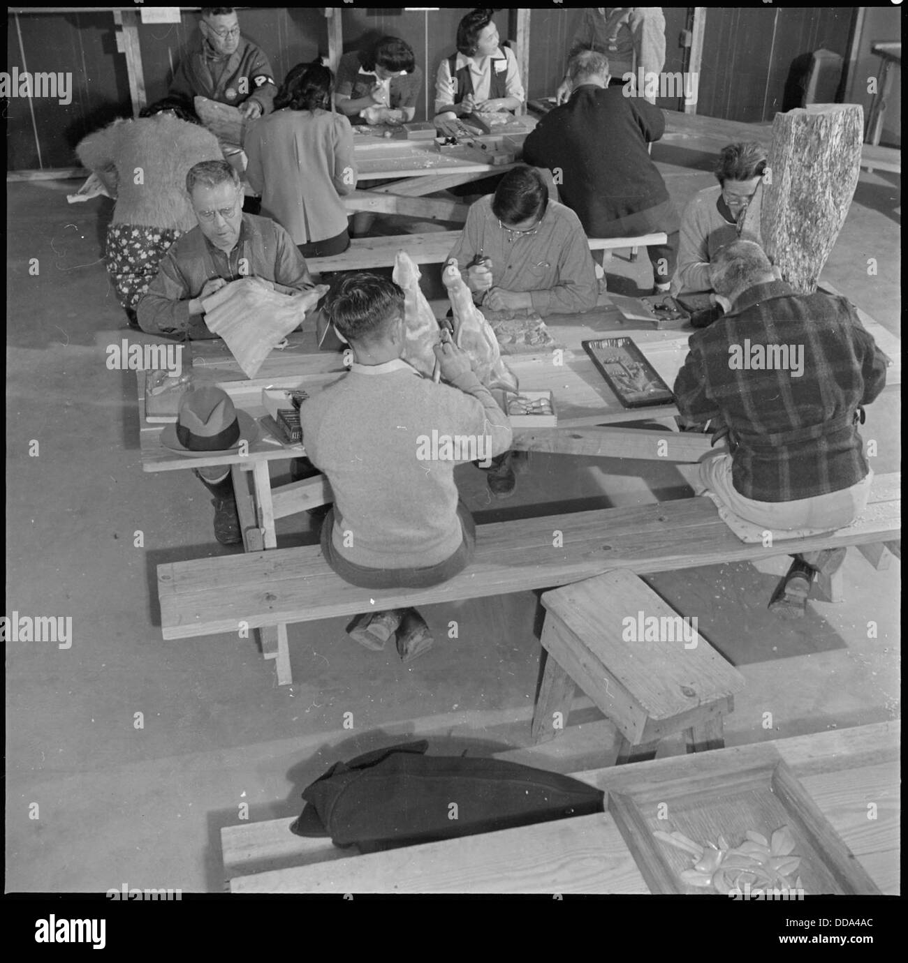 Dieses Bild zeigt eine Holzschnitzerei-Klasse im Rohwer Relocation Center in McGehee, Arkansas, wo japanisch-amerikanische Internierte während des Zweiten Weltkriegs abgehalten wurden. Stockfoto