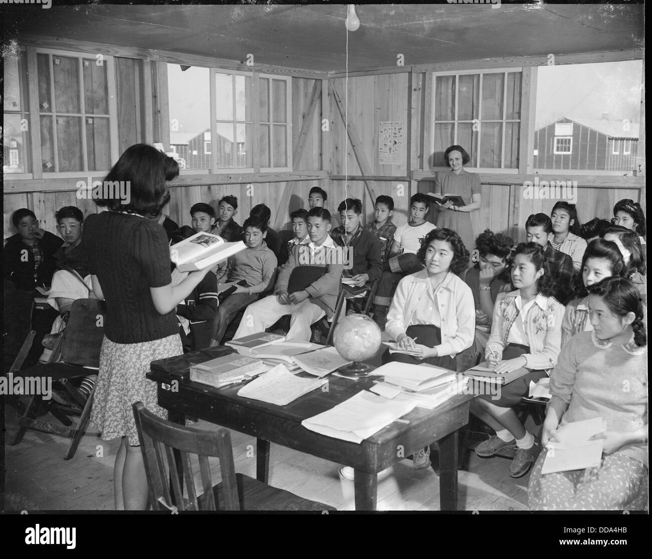 Das Bild zeigt Mrs. M. H. Ziegler, eine Lehrerin am Rohwer Relocation Center in McGehee, Arkansas, die Schüler in einem Junior High School Klassenzimmer unterrichtet. Das Zentrum war eines der Internierungslager, in dem japanische Amerikaner während des Zweiten Weltkriegs umgesiedelt wurden Stockfoto