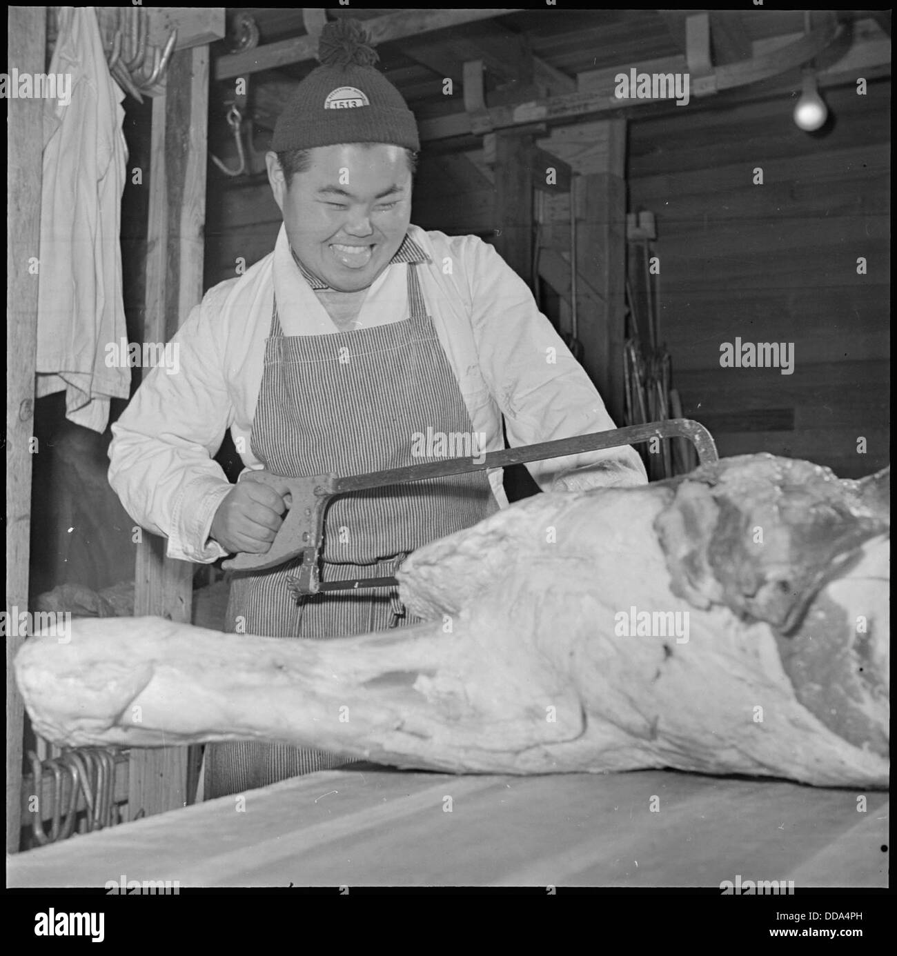 Sam Takeda, ein ehemaliger Metzger von der Westküste, wird im Rohwer Relocation Center in McGehee, Arkansas, gesehen, einem Internierungslager japanischer Amerikaner aus dem Zweiten Weltkrieg. Stockfoto