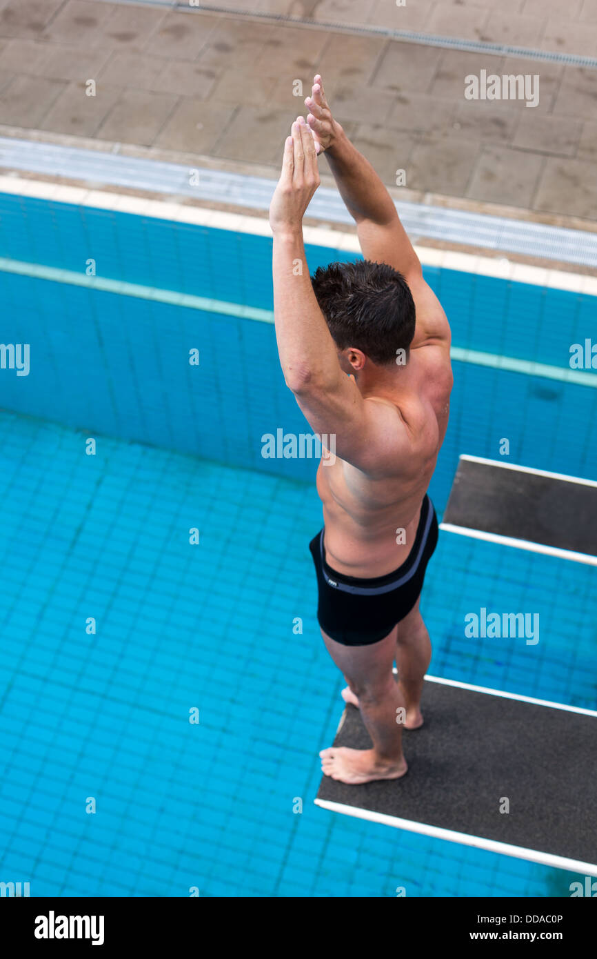 Mann bereit, springen vom Sprungbrett im Schwimmbad Stockfoto