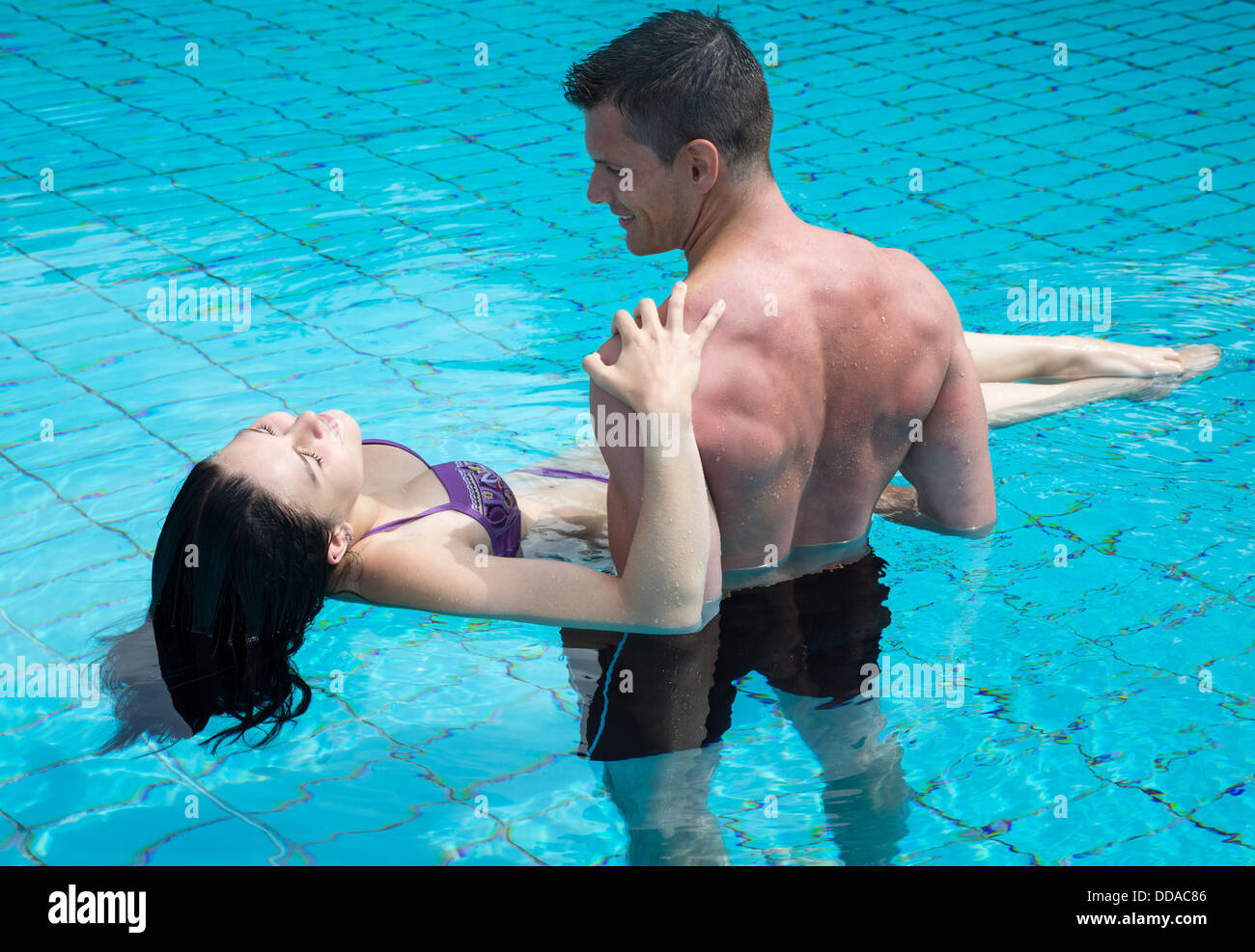 Junges attraktives Paar verliebt in das Wasser im Schwimmbad Stockfoto