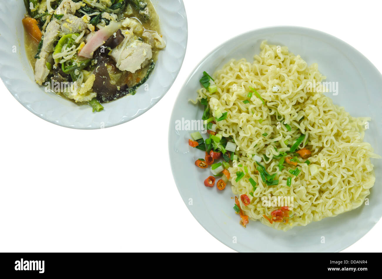 Top-Ansicht asiatische Suppe mit Schweinefleisch, Gemüse in die Schüssel und gekochten instant-Nudeln auf weiße Schale mischen, auf weißem Hintergrund Stockfoto