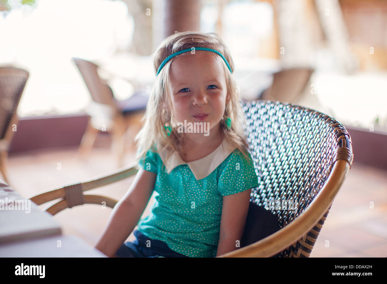 Kleines Mädchen sitzt im Stuhl im Restaurant warten auf ihr Essen Stockfotografie Alamy