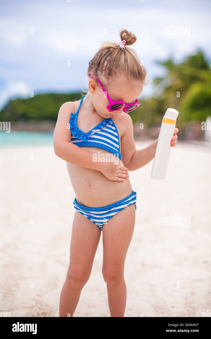 Entzückendes Mädchen im Badeanzug reibt Sonnenschutz selbst Stockfotografie  - Alamy