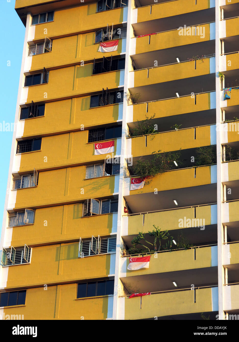 Singapurische Flaggen hängen von einem Singapur-Mehrfamilienhaus Stockfoto