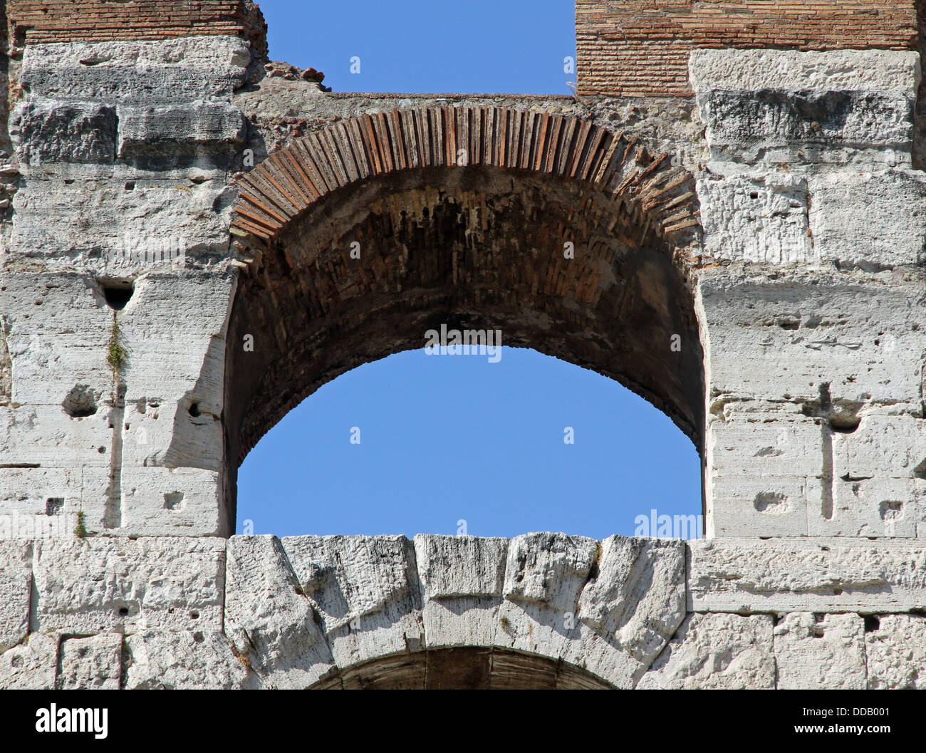 Detail von einem antiken Bogen des Kolosseums und den blauen Himmel von Rom in Italien Stockfoto
