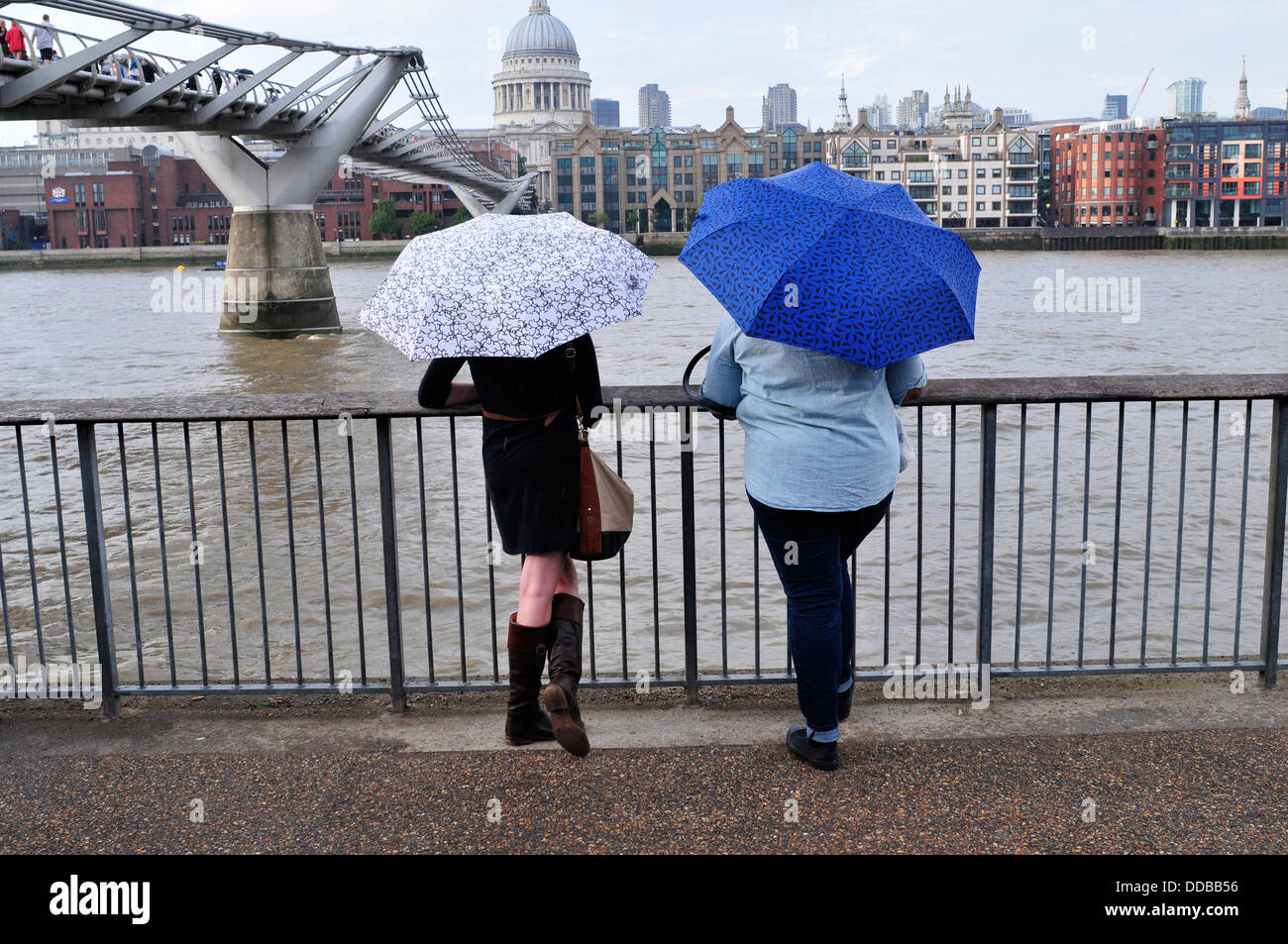 Eine Rückansicht von zwei Frauen mit Sonnenschirmen, London, UK Stockfoto