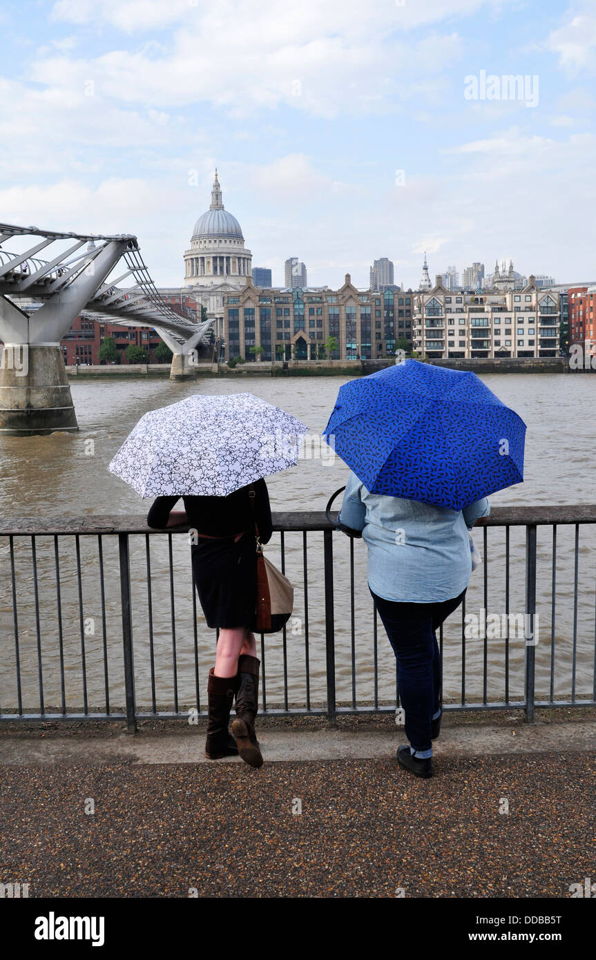 Eine Rückansicht von zwei Frauen mit Sonnenschirmen, London, UK Stockfoto