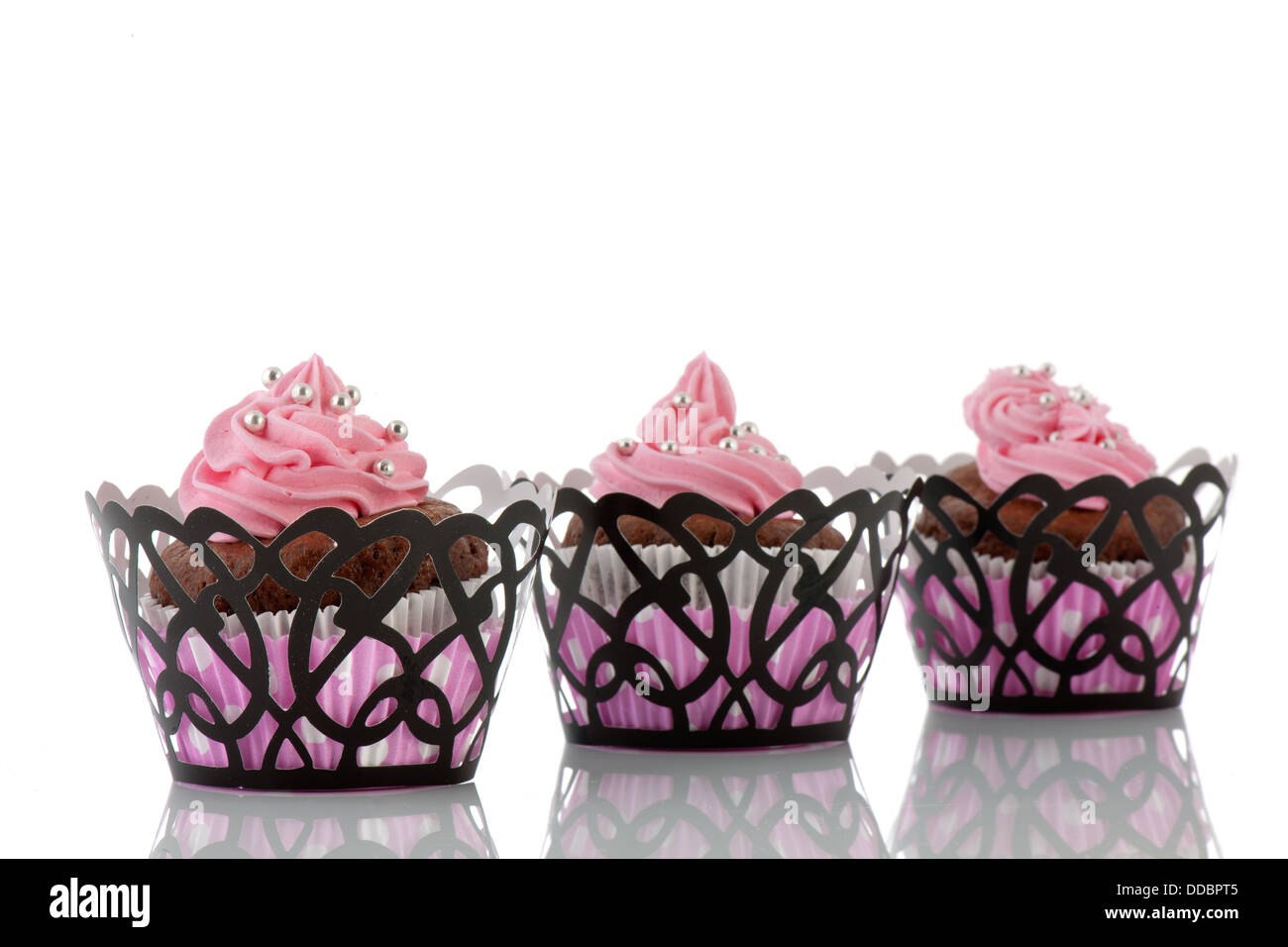 Drei Schokoladen Cupcakes mit rosa Butter Zuckerguss Stockfoto