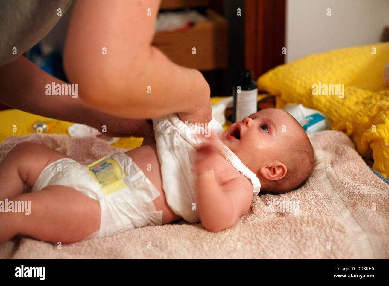 Port d'Alcudia, Mallorca, Spanien, ein Baby von der Mutter angezogen werden Stockfoto