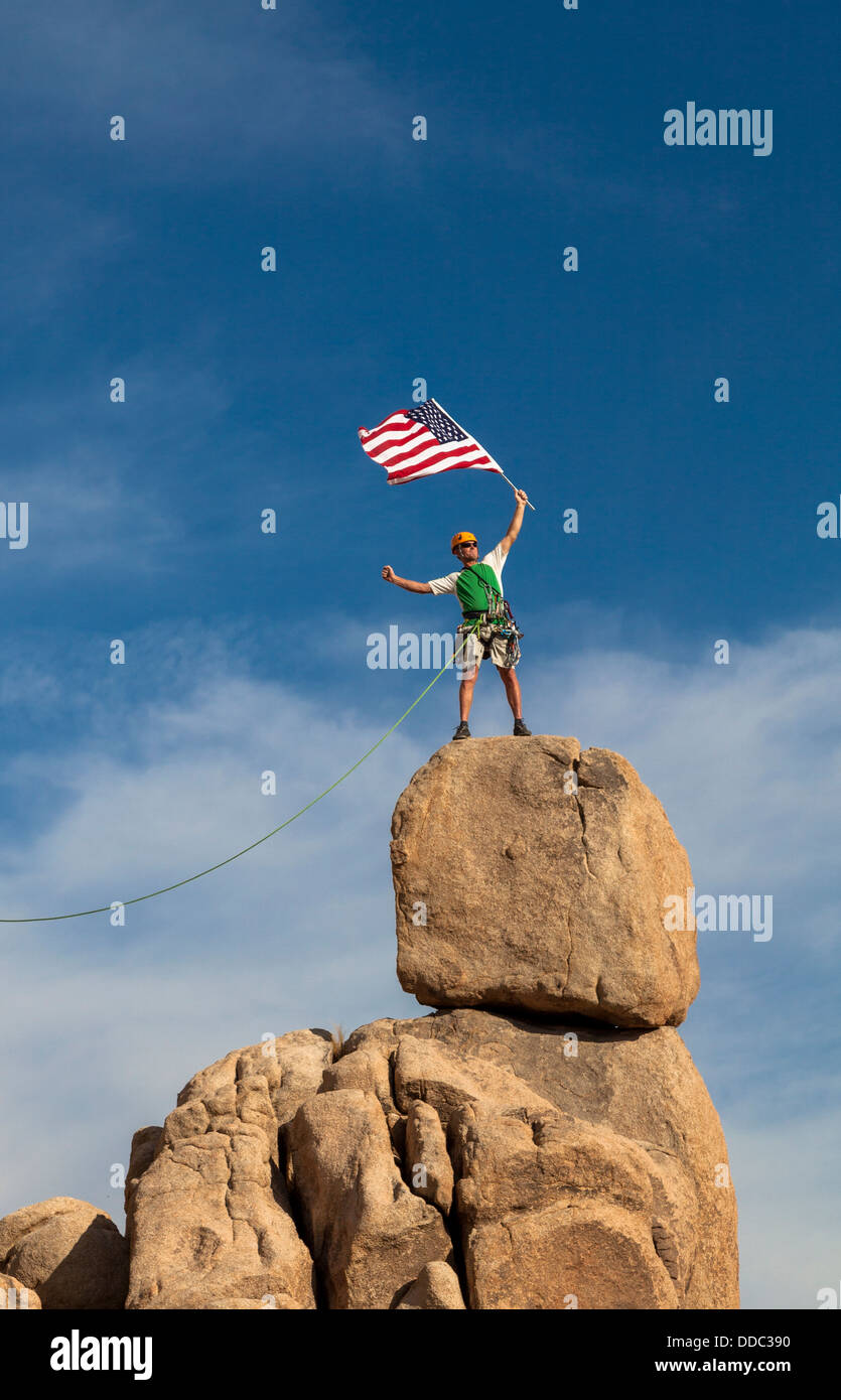 Männliche Bergsteiger erobert den Gipfel von einem anspruchsvollen Rock-Turm. Stockfoto
